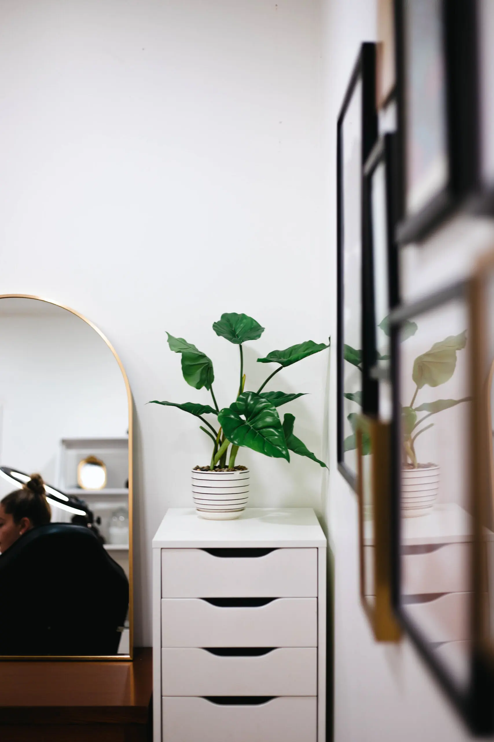 rental-suites-available Narrow room with mirror, white storage unit and wall decor