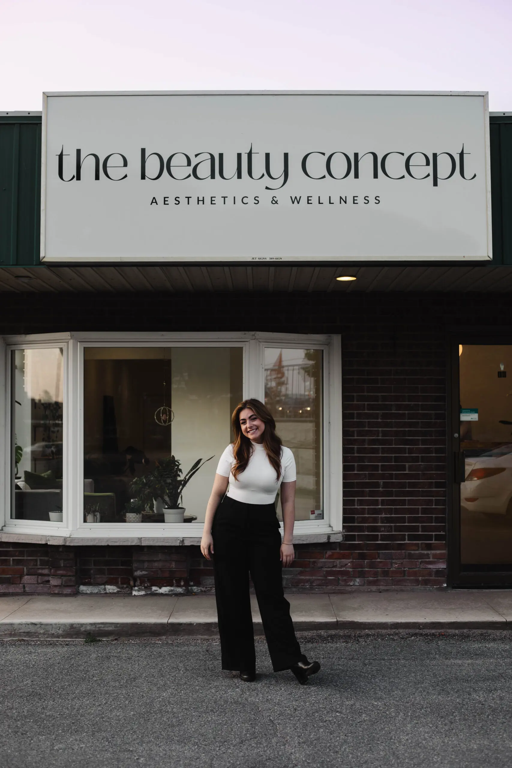 the-beauty-concept Woman posing in front of business with white sign